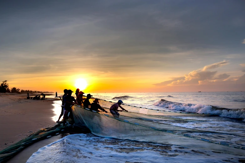 a group of people standing on top of a beach next to the ocean, by Ibrahim Kodra, pexels contest winner, fishing boat, sri lanka, blocking the sun, slide show