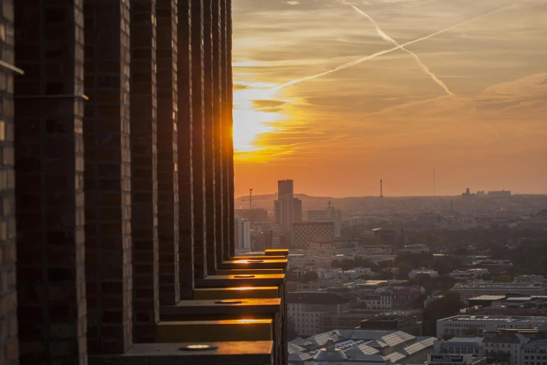 a view of a city at sunset from a high rise building, by Sebastian Spreng, pexels contest winner, berlin secession, sun shafts, brussels, tall terrace, view from the side”