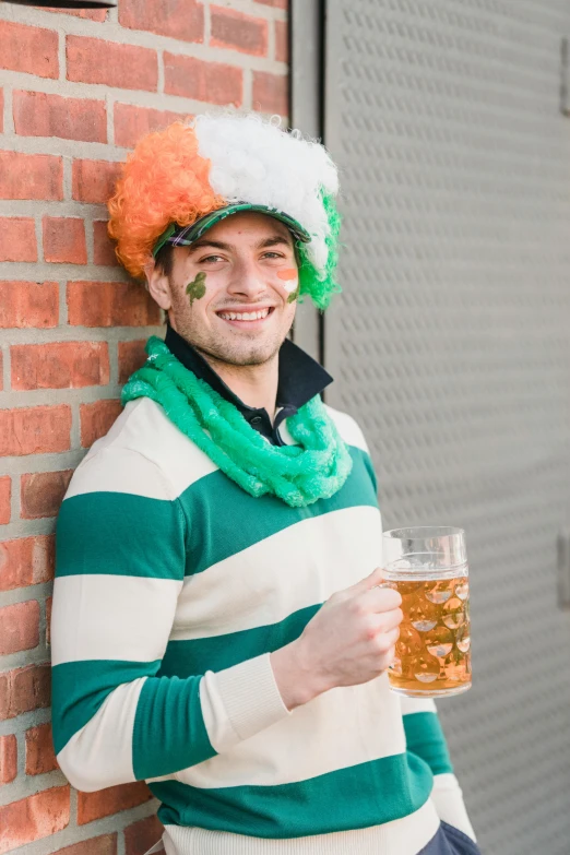 a man standing next to a brick wall holding a glass of beer, trending on reddit, celtics, striped orange and teal, man dressed as a chicken, profile image