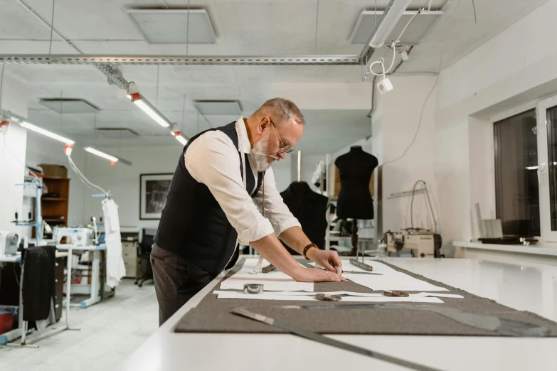 a man that is standing in front of a table, a silk screen, in style of norman foster, fashion studio, ignant, stan winston studios