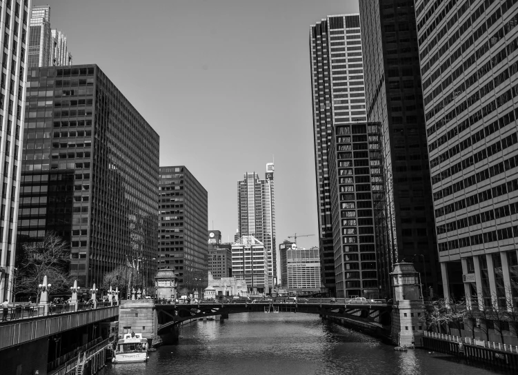 a river running through a city next to tall buildings, a black and white photo, from wheaton illinois, tourist photo, high details photo, trending photo