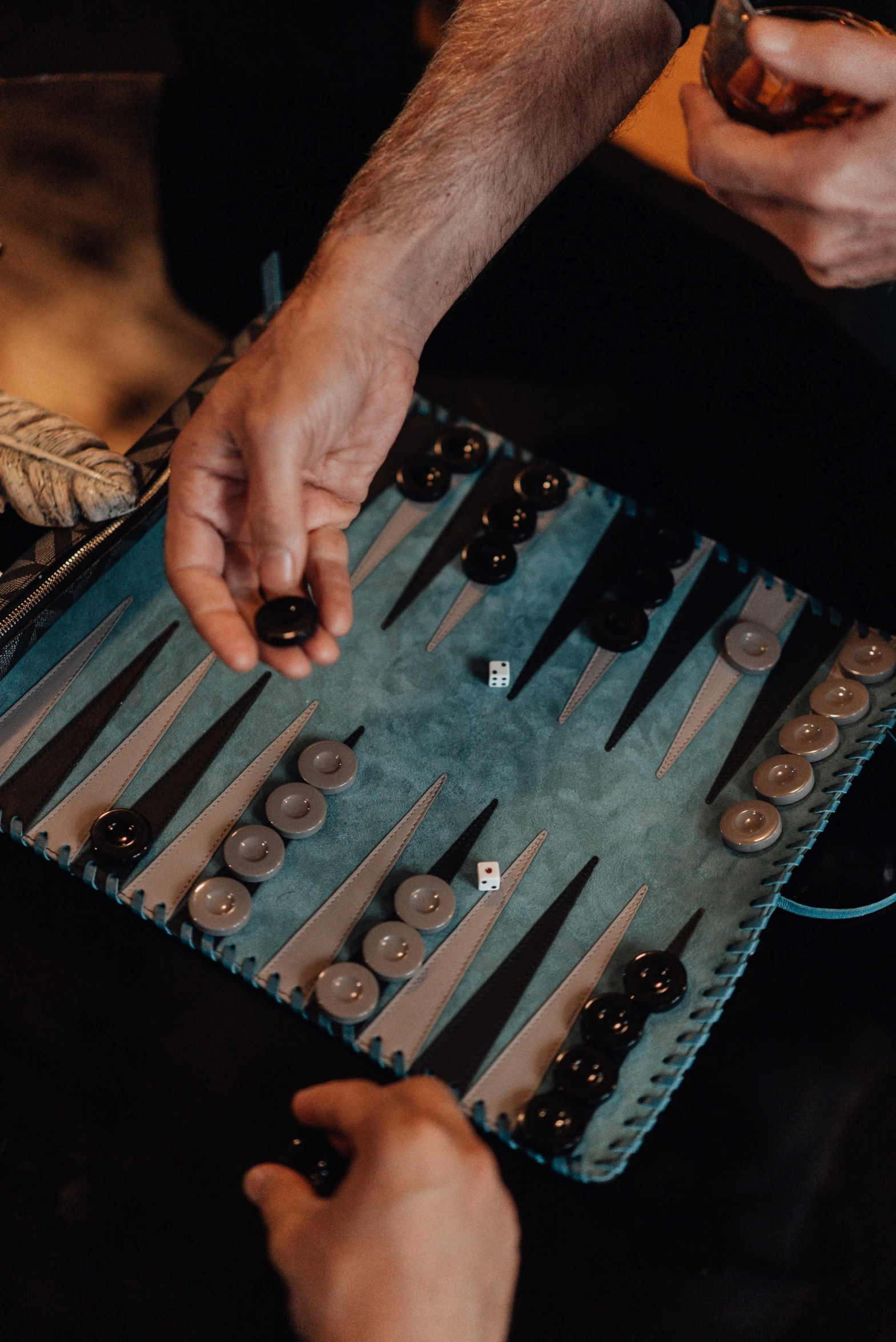 a close up of a person playing a game of backgams, by Kristian Zahrtmann, hurufiyya, taken in the early 2020s, abcdefghijklmnopqrstuvwxyz, blue, recreation