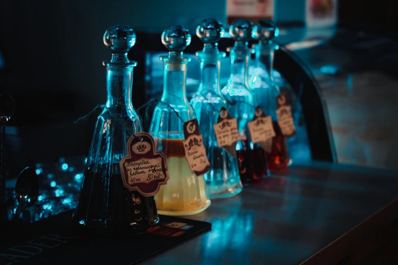 a row of liquor bottles sitting on top of a bar, pexels, magical potions, black and blue and purple scheme, at the counter, thumbnail