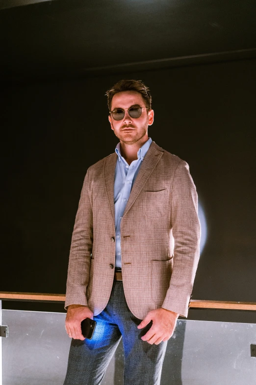 a man standing in front of a blackboard, an album cover, inspired by Michel De Caso, pexels contest winner, tan suit, wearing shades, profile image, wearing business casual dress