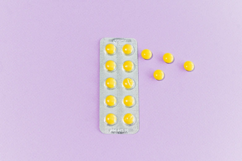 pills in a blister pack on a purple background, by Nicolette Macnamara, antipodeans, bright yellow color scheme, mid 2 0's female, on a white table, femme fetal