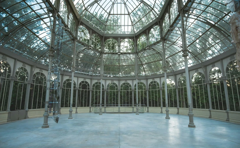 the inside of a building with a glass roof, an album cover, inspired by Dionisio Baixeras Verdaguer, unsplash contest winner, art nouveau, a park, outdoor art installation, standing in a large empty hall, madrid