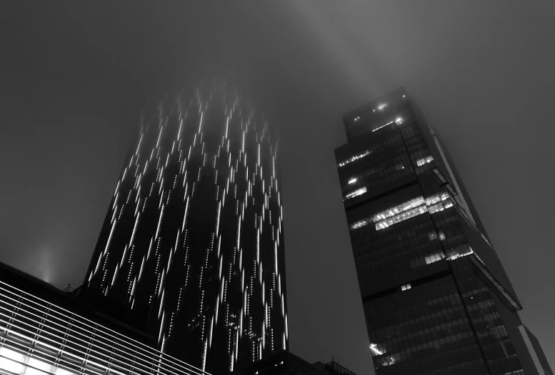 a black and white photo of skyscrapers in the fog, inspired by Hugh Ferriss, unsplash contest winner, lines of lights, tokujin yoshioka, two towers, photo taken from the ground