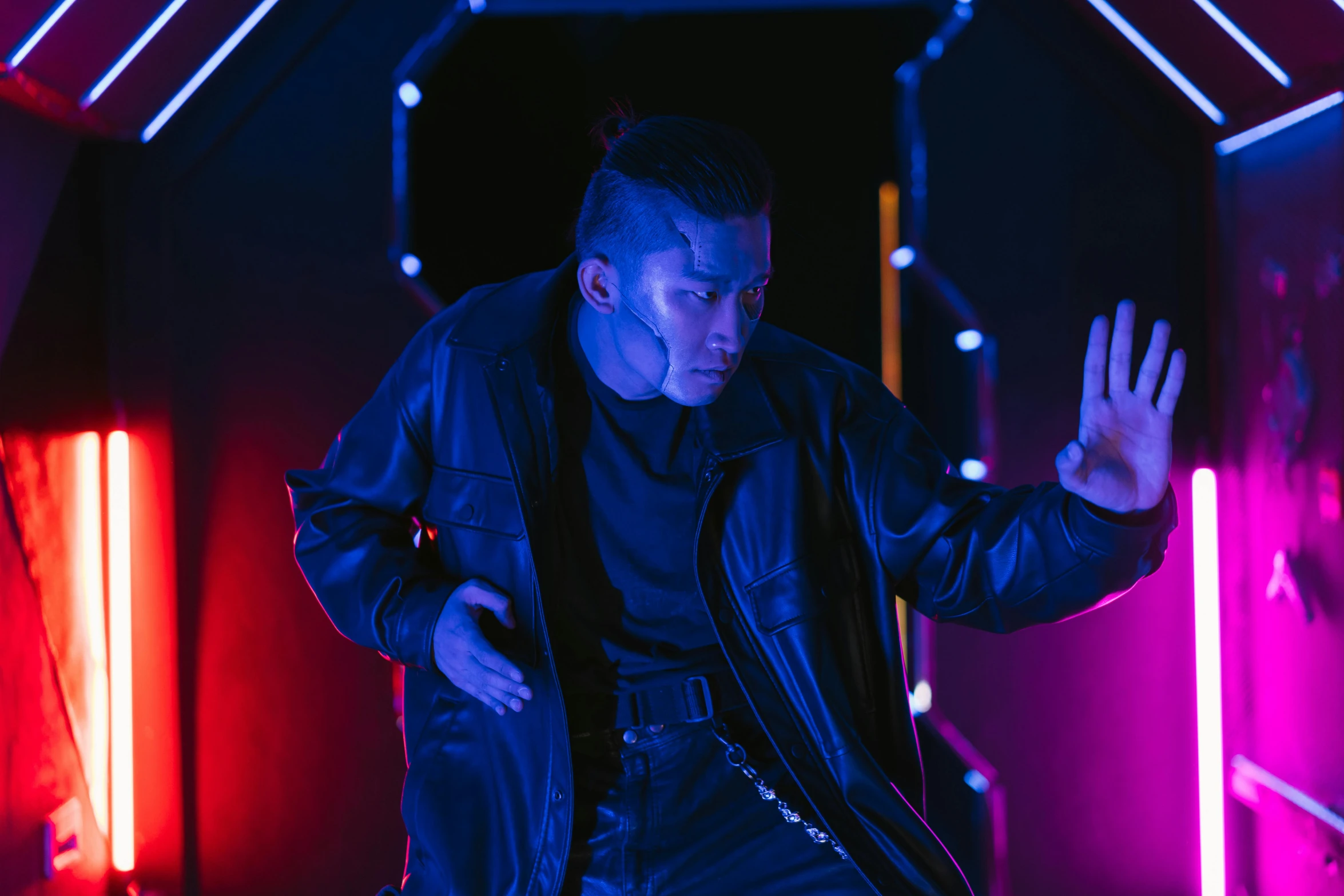 a man standing in a room with neon lights, inspired by Zhu Da, unsplash, symbolism, wearing cyberpunk leather jacket, choreographed fight scene, actor, production photo