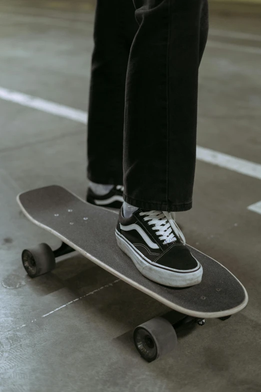 a person standing on a skateboard in a parking lot, a pair of ribbed, vanta black, profile image, a high angle shot