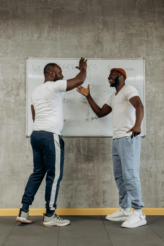 two men standing in front of a white board, pexels contest winner, black arts movement, reaching out to each other, afro tech, balancing the equation, performance