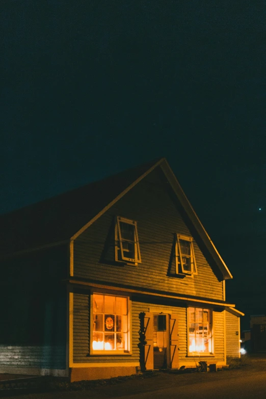 a house sitting on the side of a road at night, an album cover, by Andrew Domachowski, pexels contest winner, postminimalism, yellowish light, farmhouse, intense knowledge, front lit