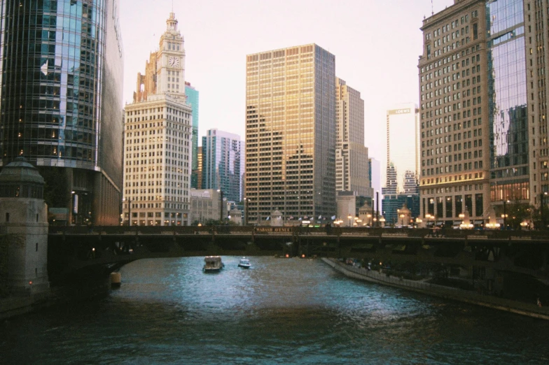 a river running through a city next to tall buildings, a photo, by Robbie Trevino, vsco film grain, chicago, album cover, quaint