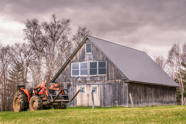 a tractor parked in front of a barn, by Jim Nelson, pexels contest winner, overcast skies, gambrel roof building, canvas, spring evening