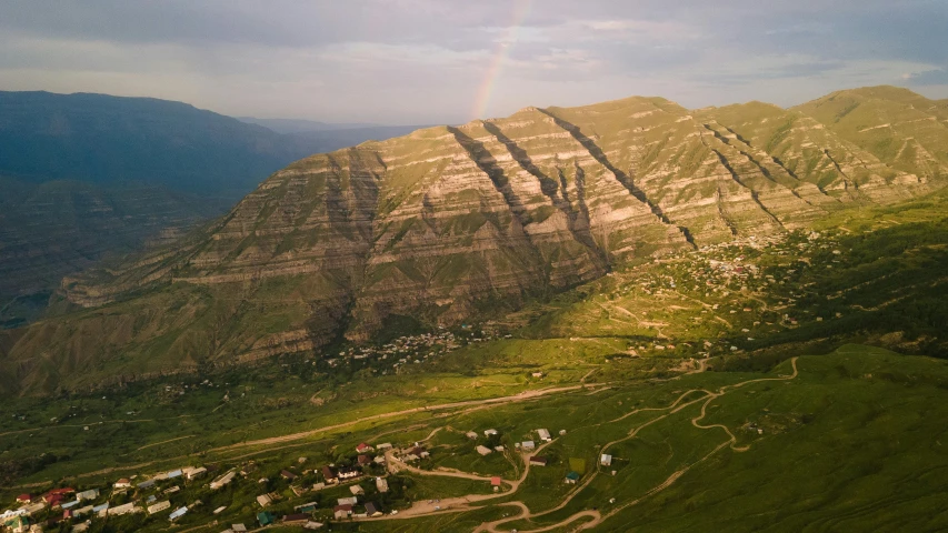 a rainbow shines in the sky over a valley, pexels contest winner, les nabis, ayanamikodon and irakli nadar, aerial, stacked image, early morning lighting