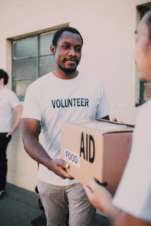 a man handing a box to a woman, by Francis Helps, pexels contest winner, lab coat and tee shirt, hunger, virgil abloh, emergency