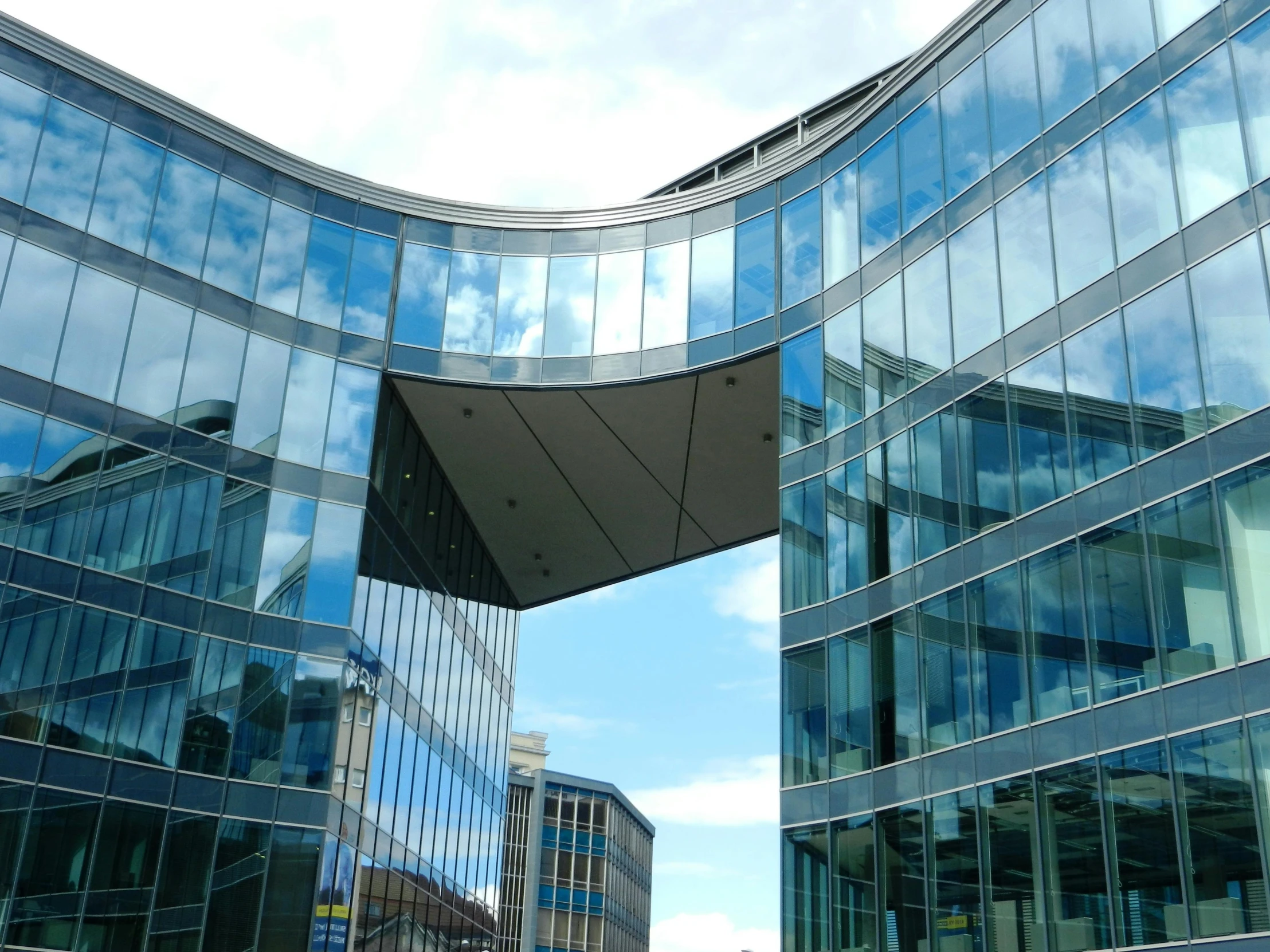 a couple of buildings that are next to each other, a picture, inspired by Richard Wilson, flickr, steel archways, clear blue skies, lots of glass details, eka's portal