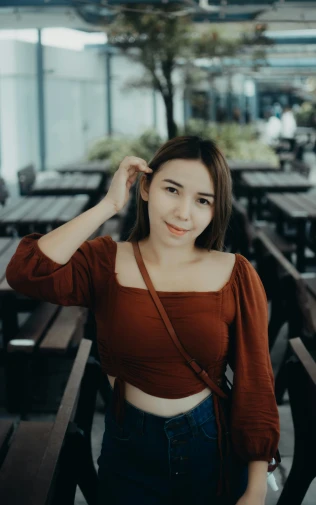 a woman posing for a picture in a restaurant, inspired by Ruth Jên, pexels contest winner, wearing a cropped tops, brown:-2, headshot profile picture, malaysian