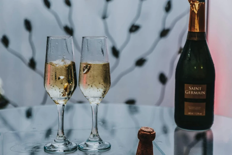 two glasses of champagne next to a bottle of champagne, pexels contest winner, josh grover, glazed, background image, champagne on the table