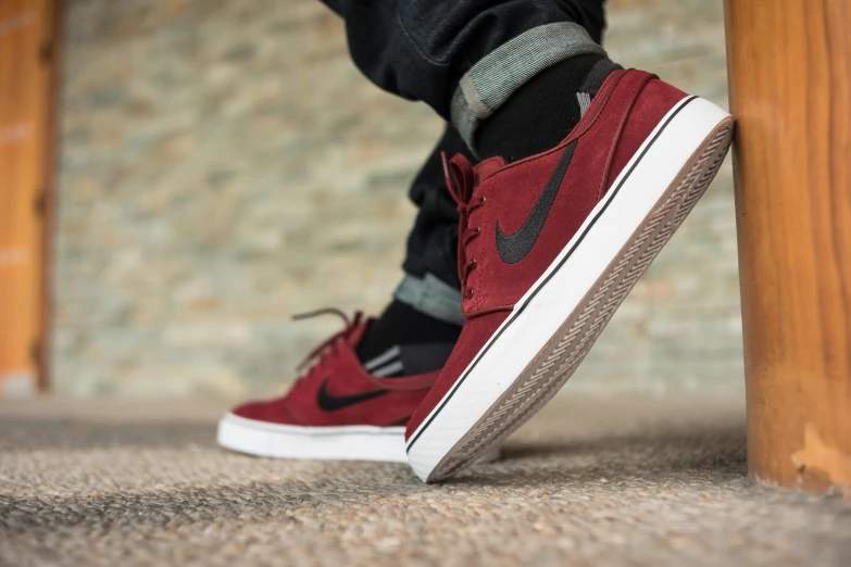 a close up of a person's shoes on the ground, a digital rendering, by Niko Henrichon, unsplash, red shirt brown pants, skateboarder style, maroon and white, shallow dof