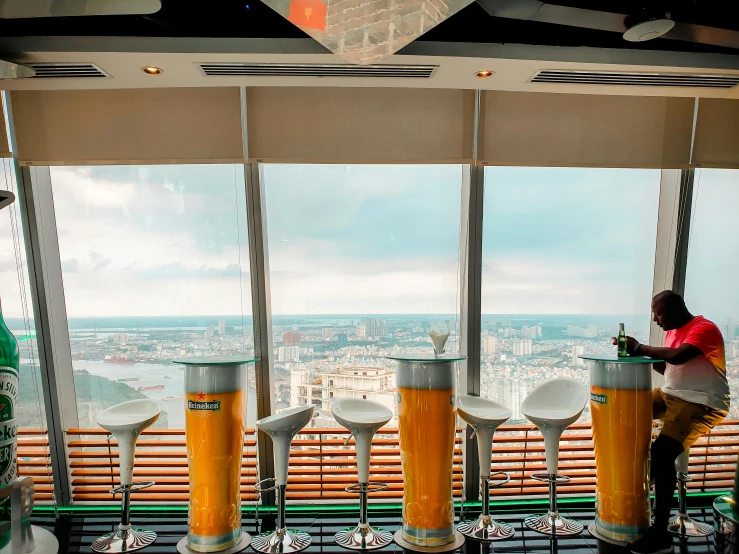 a man that is standing in front of a window, a picture, inside a beer glass, observation deck, skybox, beers on the table