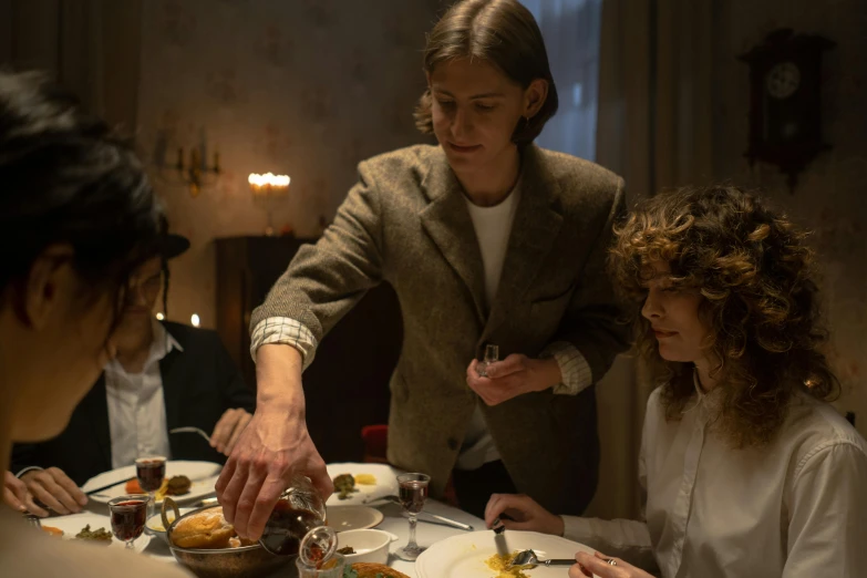 a group of people sitting around a dinner table, ignant, cinestill, woman holding another woman, serving suggestion