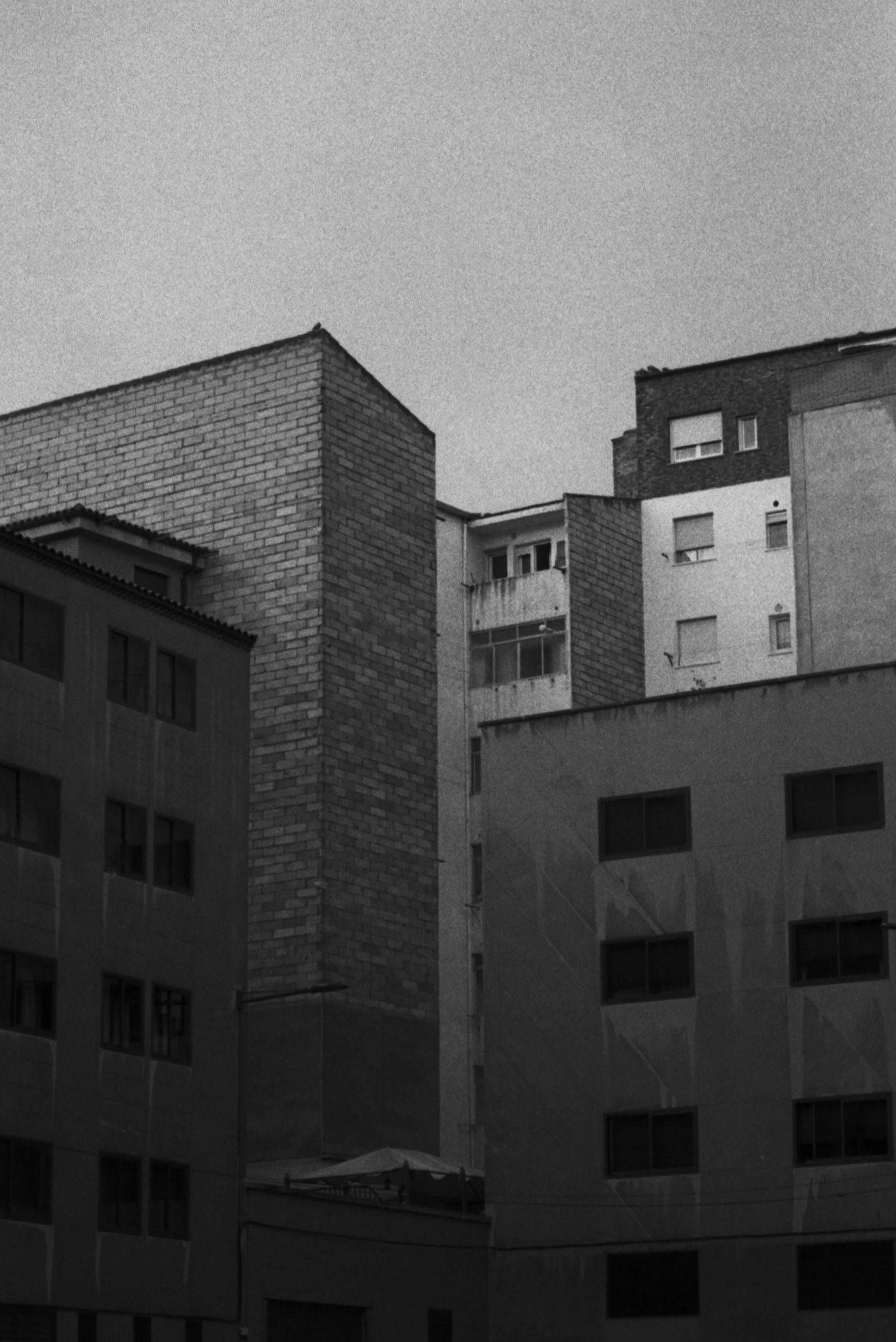 a black and white photo of some buildings, inspired by André Kertész, unsplash, faded colours, low quality photograph, blanco y negro, lut