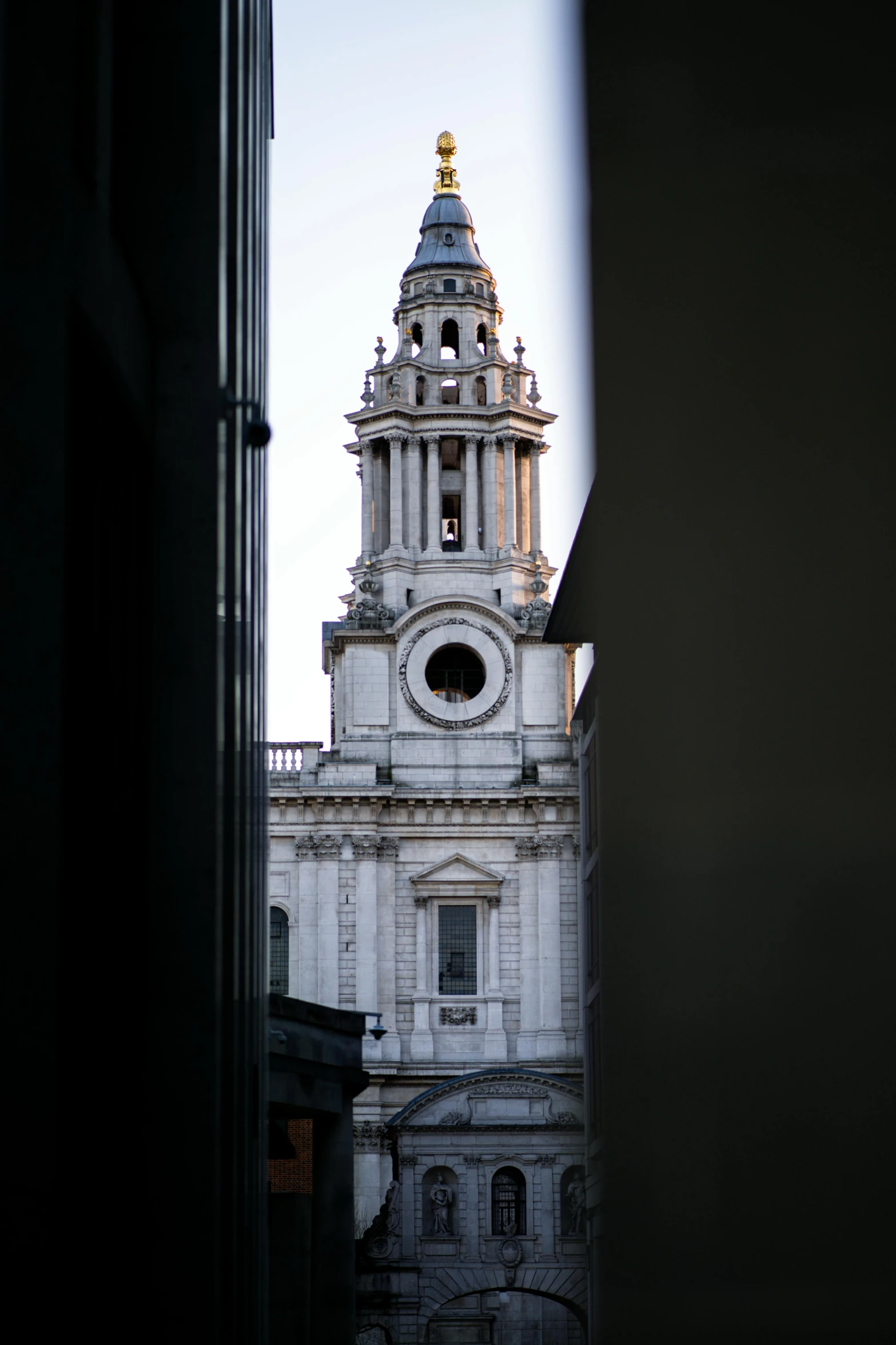 a view of a clock tower through a window, inspired by Christopher Wren, baroque, white marble buildings, over the shoulder, lit from above, looking towards camera