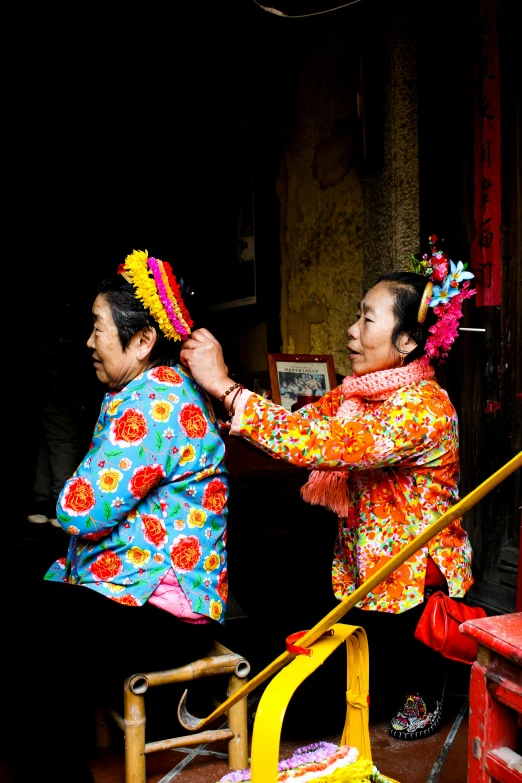 a couple of women standing next to each other, inspired by Xie Huan, happening, worshipers, her hair is tied above her head, slide show, colourful clothing