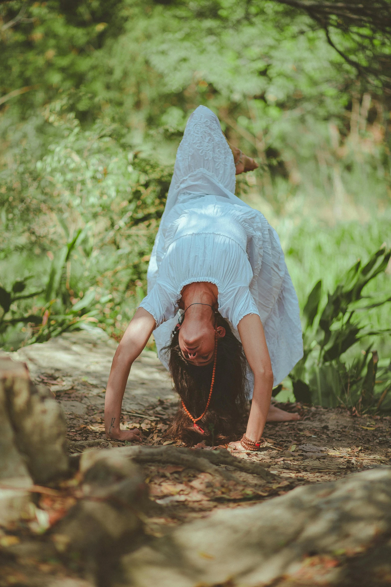 a woman doing a handstand in the woods, pexels contest winner, arabesque, kundalini energy, face down, white, lizard pose