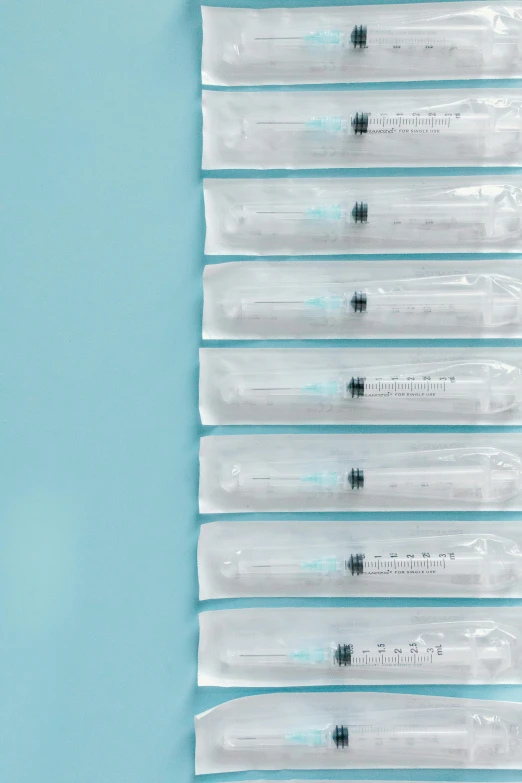 a bunch of plastic bags on top of a blue surface, holding syringe, sleek spines, promo image, 6 pack