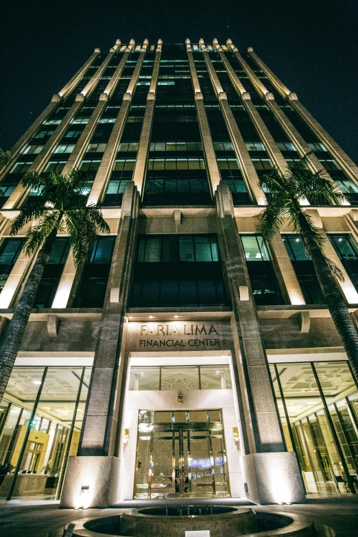 a tall building lit up at night with palm trees, palladium, private academy entrance, thumbnail, manila