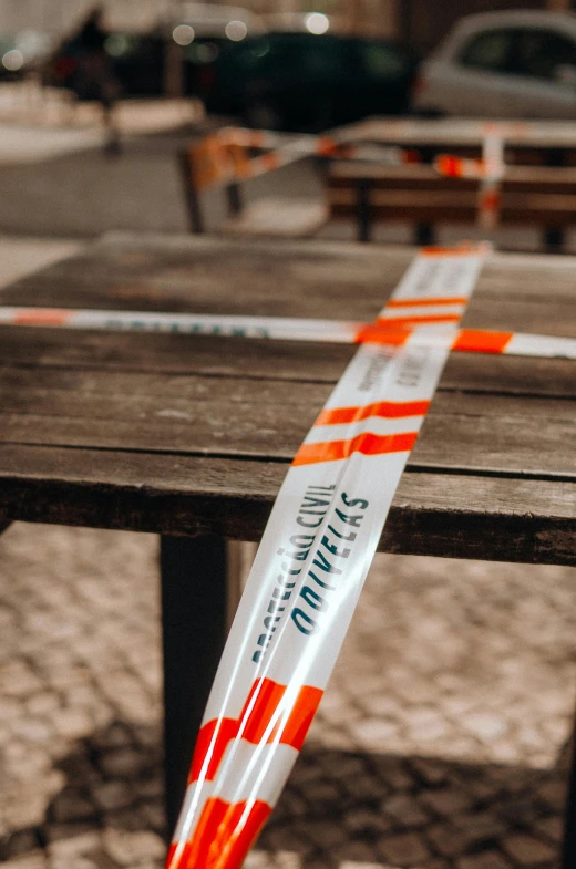 an orange and white tape sitting on top of a wooden table, by Adam Marczyński, pexels, happening, street signs, cafe tables, garters, profile image