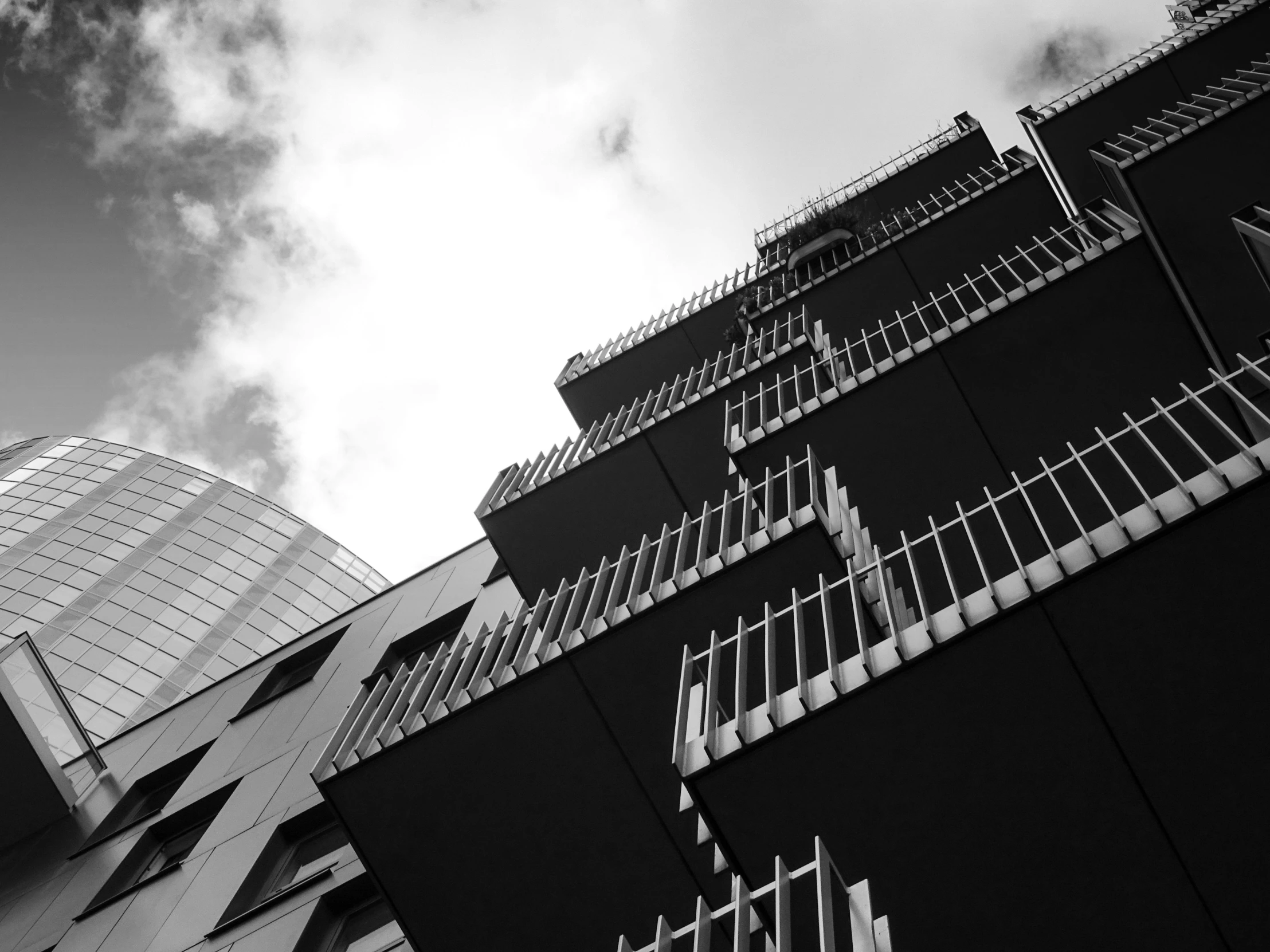 a black and white photo of a tall building, unsplash, brutalism, elaborate latticed balconies, low angle photo, high quality upload, monochrome color