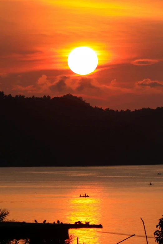 the sun is setting over a body of water, by Doug Ohlson, sumatraism, large twin sunset, indonesia, f / 2 0, suns