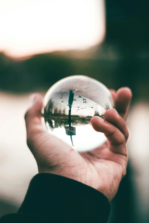 a person holding a crystal ball in their hand, a picture, by Jesper Knudsen, pexels contest winner, instagram post, everything enclosed in a circle, looking to the right, holding a stuff