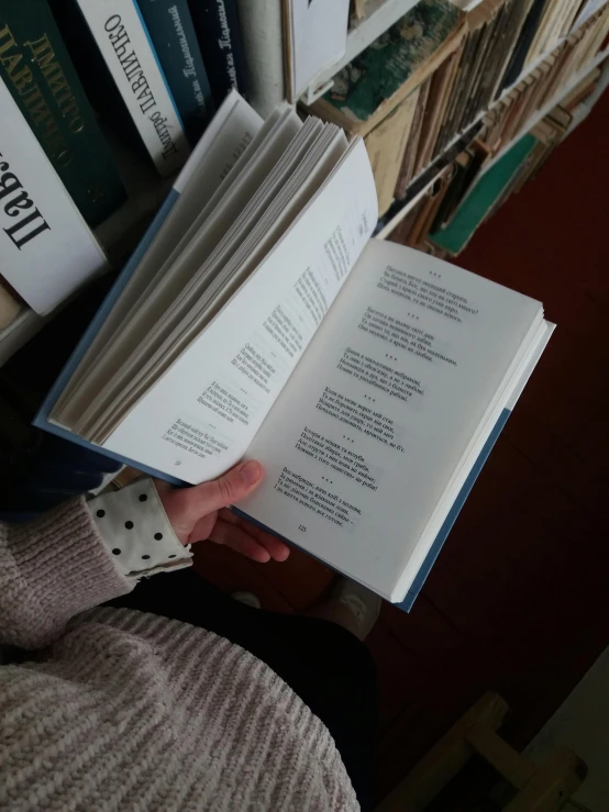 a person reading a book in front of a pile of books, by Romain brook, low quality photo, english text, pov photo, mary anning