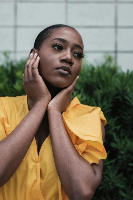 a woman in a yellow dress talking on a cell phone, an album cover, by Lily Delissa Joseph, trending on pexels, looking away from camera, hand on her chin, light-brown skin, pr shoot