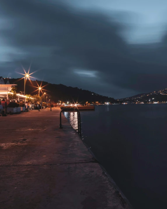 a pier next to a body of water at night, on a cloudy day, nightlife, wellington, digital image