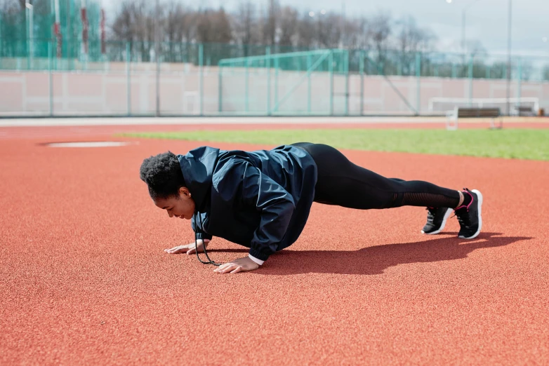 a woman doing push ups on a baseball field, pexels contest winner, wearing a track suit, 🚿🗝📝, profile image, square