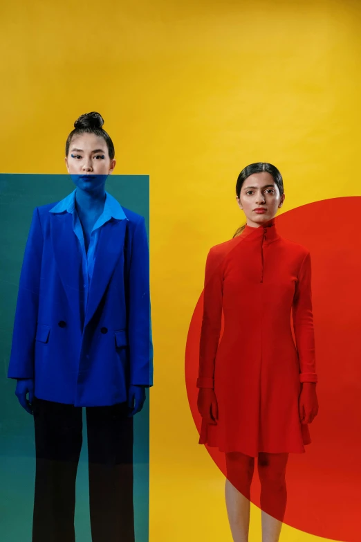 a couple of people standing next to each other, an album cover, inspired by Wang Duo, color field, asian women, blue coat, red and yellow, issey miyake