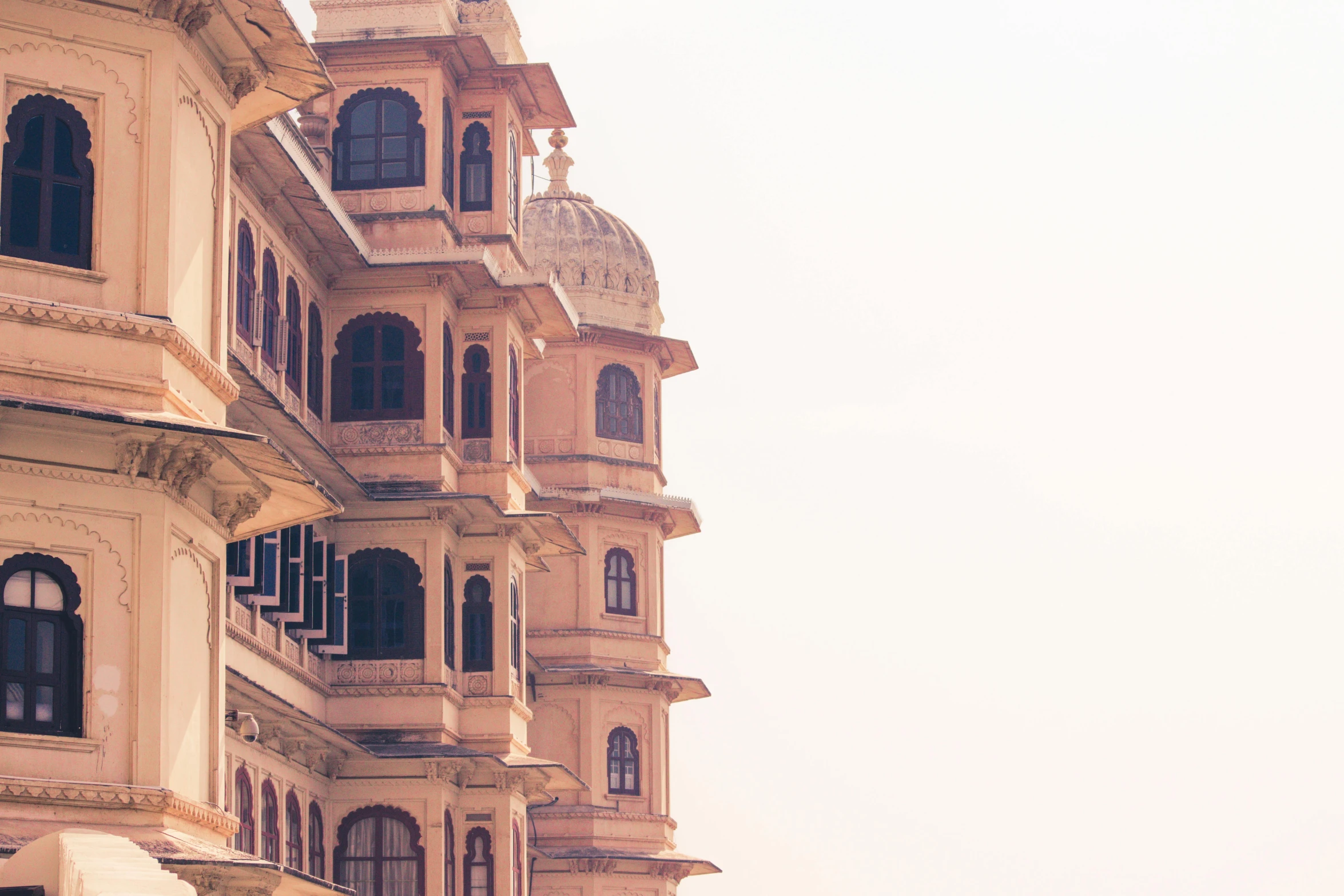 a group of people walking down a street next to tall buildings, inspired by Matthias Jung, unsplash contest winner, renaissance, painting of mehrangarh fort, pink and gold color palette, faded and dusty, in balcony of palace