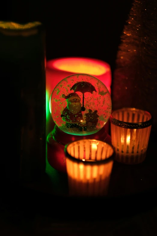 a couple of candles sitting on top of a table, a picture, light show, snowglobe, spooky lighting, slide show