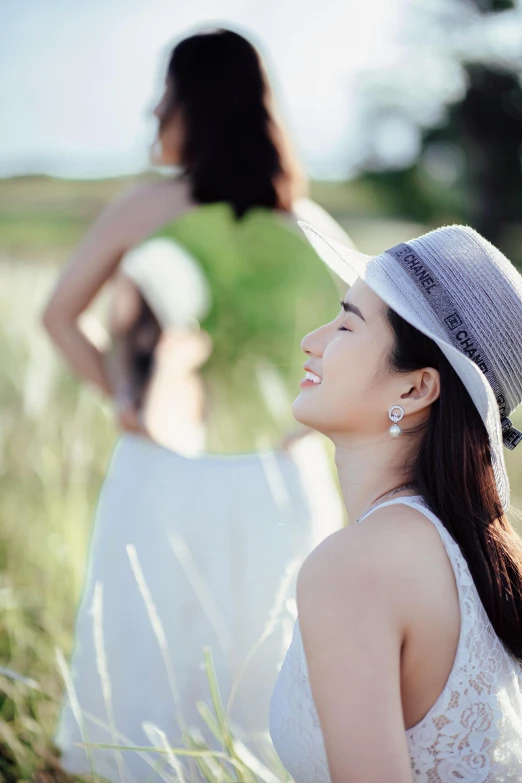 a woman sitting in a field wearing a hat, by Tan Ting-pho, pexels contest winner, elegant smiling pose, profile pic, white, excitement