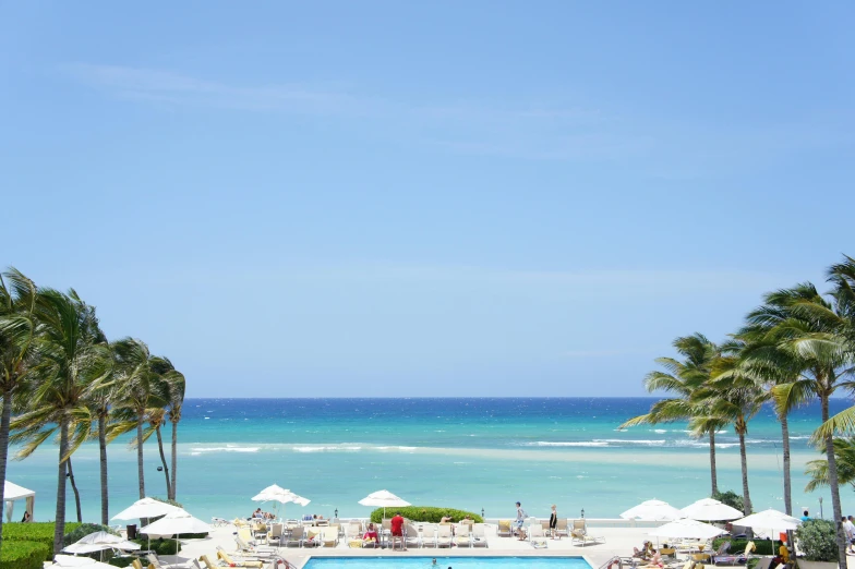 a swimming pool surrounded by palm trees next to the ocean, sea - green and white clothes, paper, overlooking, caribbean