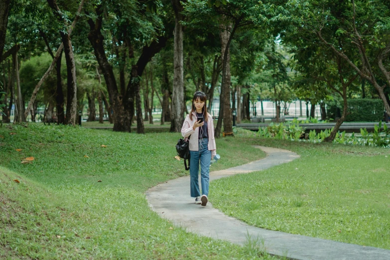a woman walking down a path in a park, by Tan Ting-pho, visual art, [ cinematic, tourist, full body photo, college