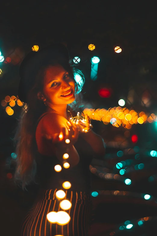 a woman holding a string of lights in her hands, pexels contest winner, renaissance, orange and cyan lighting, light smiling, 4 5 mm bokeh, instagram post