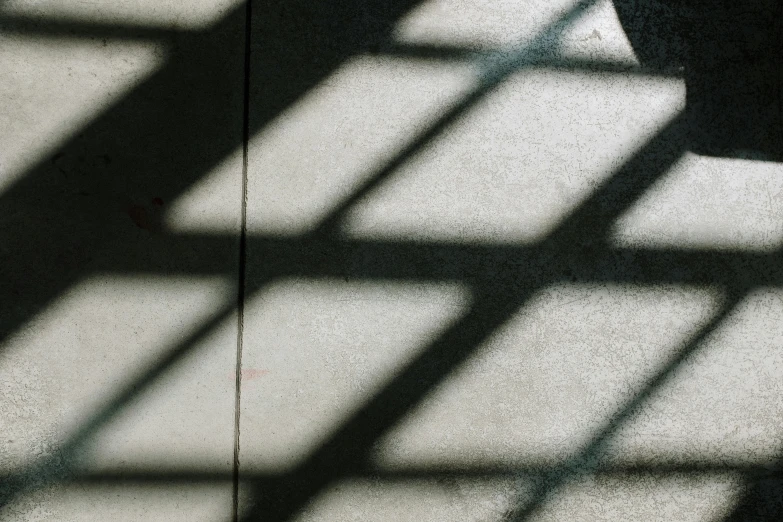 a clock sitting on top of a table next to a window, pexels contest winner, light and space, faces covered in shadows, on a checkered floor, behind bars, shadow gradient