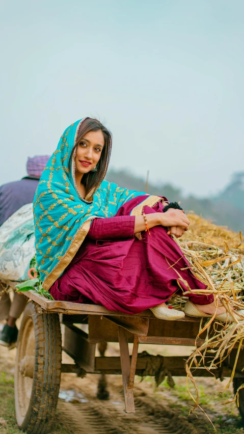 a woman sitting on top of a cart filled with hay, an album cover, by Manjit Bawa, pexels contest winner, wearing traditional garb, 15081959 21121991 01012000 4k, actress, candid shot