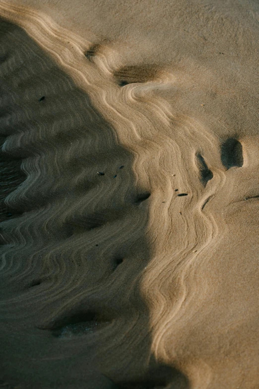 footprints in the sand on a beach, unsplash contest winner, australian tonalism, looking down from above, dune (2021), contours, irrdescent glow