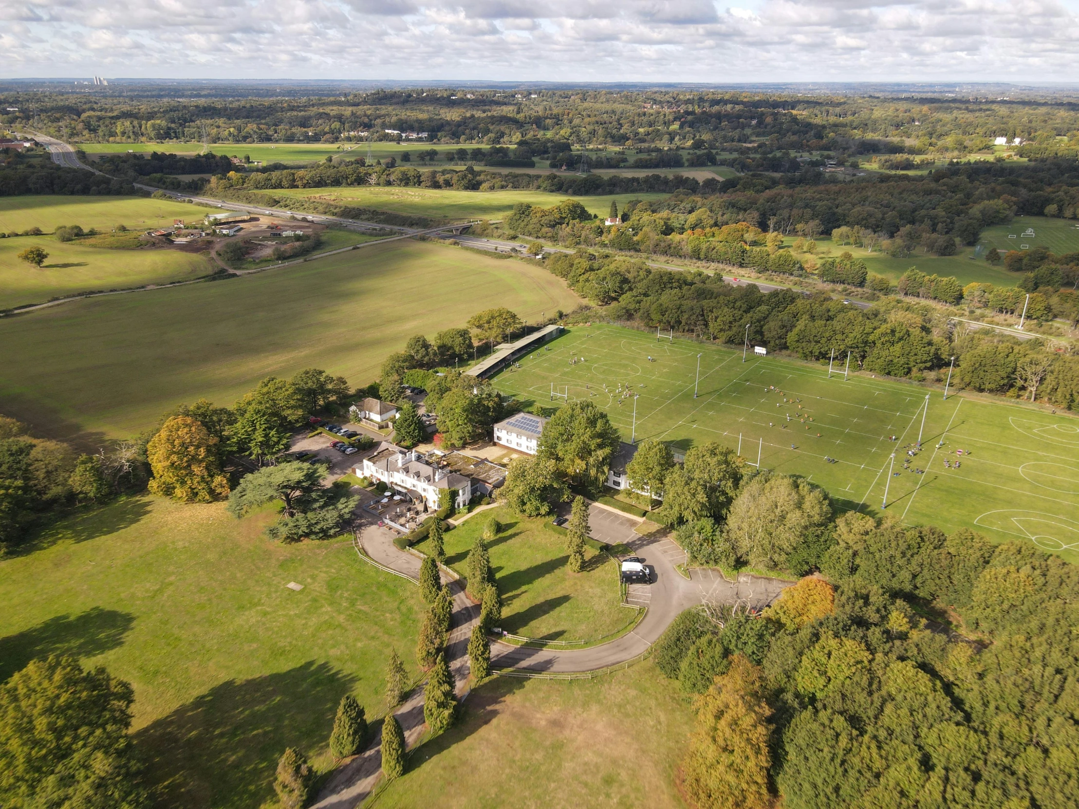 an aerial view of a farm in the country, by Julian Allen, stadium setting, esher, football, white